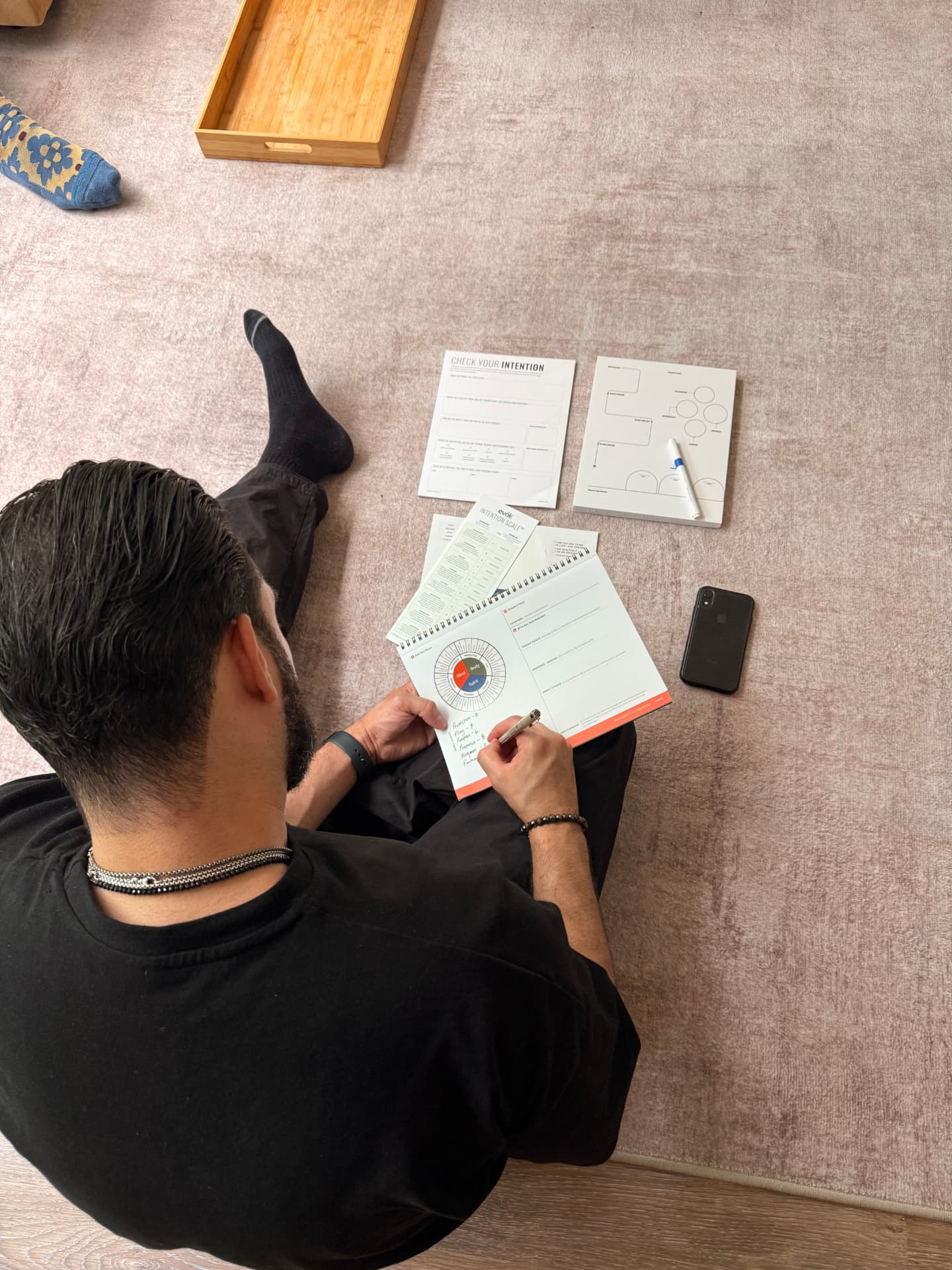 Overhead view of a man in a black shirt writing in the ManUScript workbook